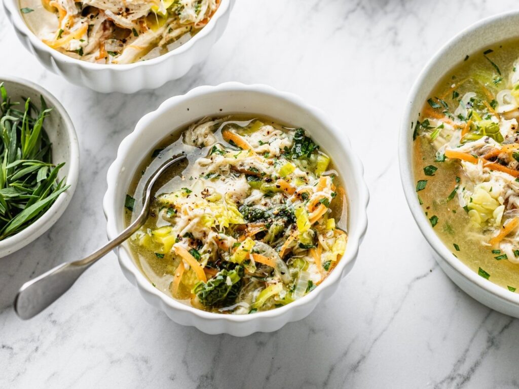 Chicken and vegetable broth served in white bowls, a nourishing, blood sugar–balancing meal ideal for reducing weight gain and belly fat in perimenopause.