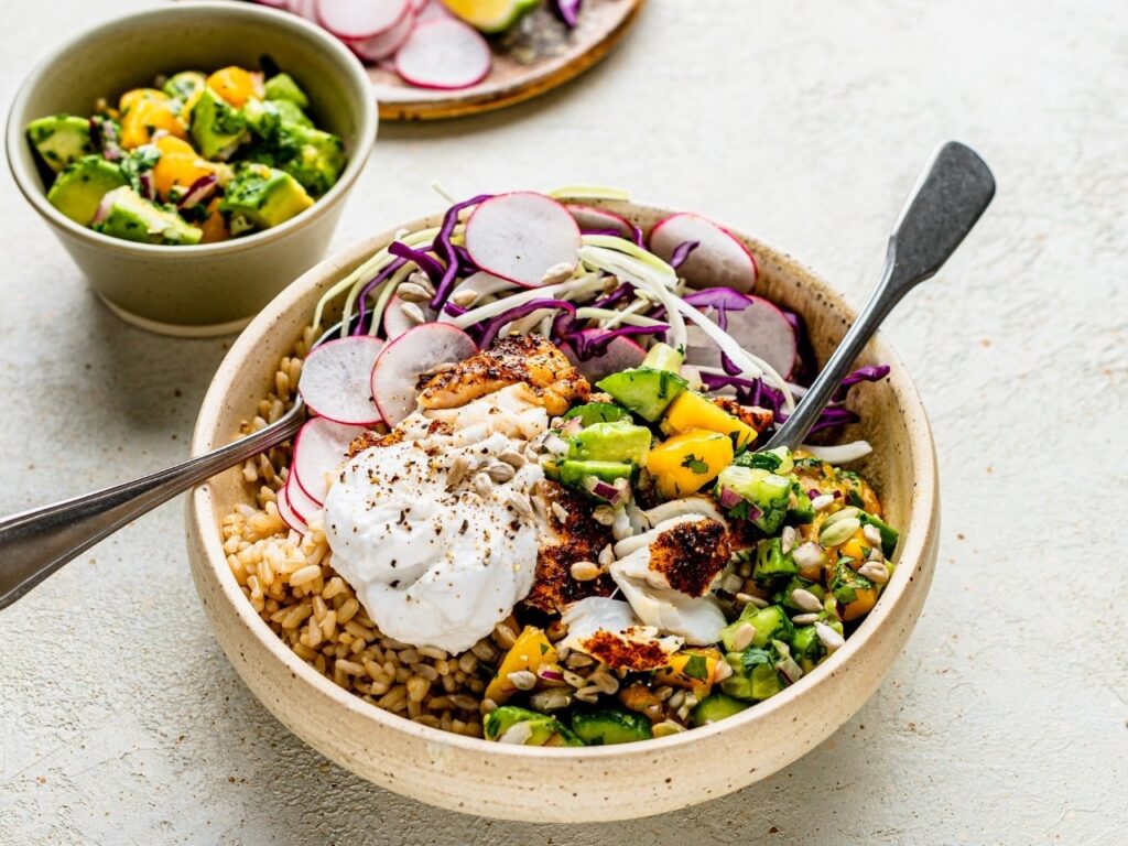 Bright burrito bowl with shredded cabbage, radish, mango and avocado, showcasing fibre-rich non-starchy vegetables for hormone and metabolic support in perimenopause