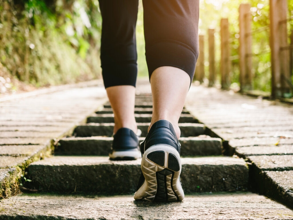 Close-up of a woman walking up outdoor steps, representing daily movement to support weight and fat loss in perimenopause