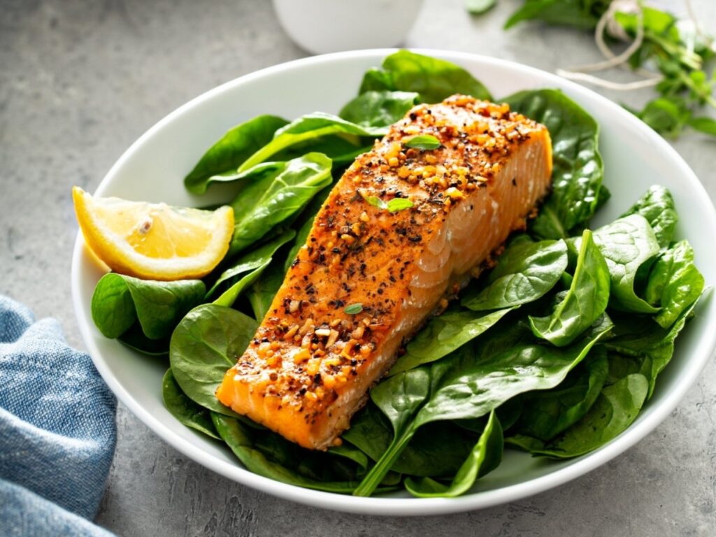 Grilled Mediterranean za’atar salmon fillet served on a bed of fresh spinach — a nutrient-dense meal rich in omega-3s, complete protein, iodine and zinc to support weight loss and hormone health in perimenopause