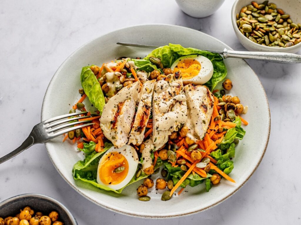 Grilled chicken Caesar salad with soft-boiled egg, a high-protein meal to support fat loss and muscle maintenance in perimenopause