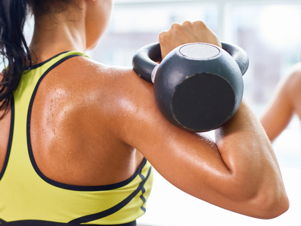 Close-up of woman holding a kettlebell in rack position — demonstrating strength training technique for women in midlife